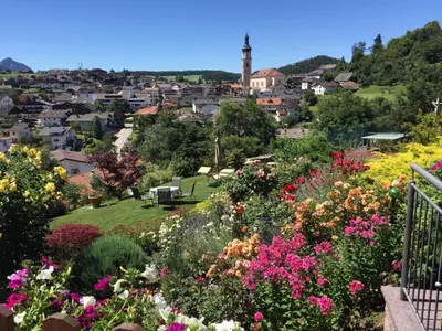 a view of a city from a garden with flowers at Appartements Plattnerhof in Castelrotto