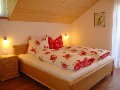 a bedroom with a bed with red pillows at Thalerhof in Perca
