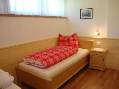a bed with red pillows on it in a room at Thalerhof in Perca