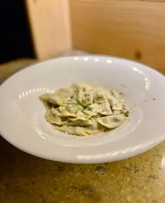 a white plate of food on a table at Hotel Garni Edy in Daiano