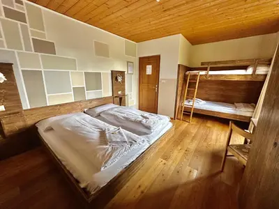 a bedroom with a bed and two bunk beds at Hotel Garni Edy in Daiano