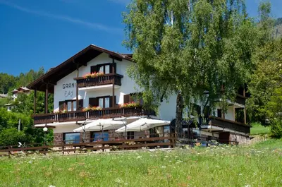 a building with umbrellas in front of it at Hotel Garni Edy in Daiano