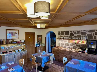 a restaurant with tables and chairs in a room at Hotel Garni Edy in Daiano