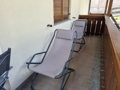 three empty chairs lined up against a wall at Col Rodella in Campitello di Fassa