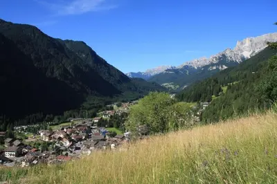 a village in a valley with mountains in the background at Col Rodella in Campitello di Fassa