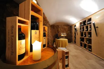 a tasting room with bottles of wine and a candle at Villa Orso Grigio in Ronzone