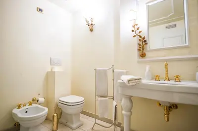 a white bathroom with a toilet and a sink at Villa Orso Grigio in Ronzone