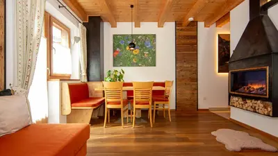a dining room with a table and chairs and a fireplace at Roderhof in Braies