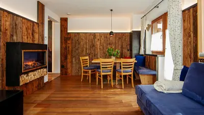 a living room with a table and chairs and a fireplace at Roderhof in Braies