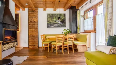 a dining room with a table and chairs and a fireplace at Roderhof in Braies