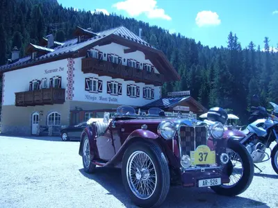 an old car is parked in front of a building at Rifugio Monti Pallidi in Canazei