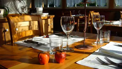 a wooden table with wine glasses and tomatoes on it at Rifugio Monti Pallidi in Canazei