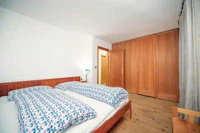 a bedroom with a bed and wooden cabinets at Apartments Stina in Ortisei