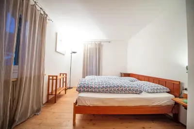 a bedroom with a bed with blue and white pillows at Apartments Stina in Ortisei
