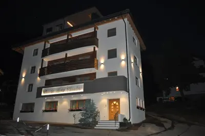 a white building with a sign on it at night at Piccolo Hotel Claudia No Pets in San Vigilio Di Marebbe