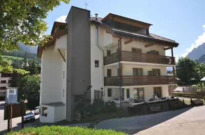 a large white building with wooden balconies at Piccolo Hotel Claudia No Pets in San Vigilio Di Marebbe