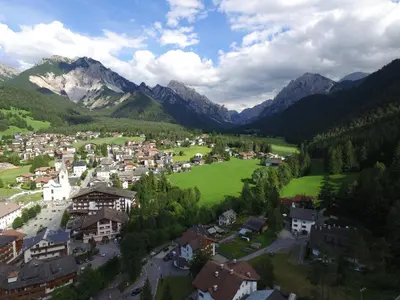 a town in a valley with mountains in the background at Piccolo Hotel Claudia No Pets in San Vigilio Di Marebbe