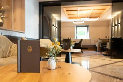 a table with a vase of flowers on top of it at Hotel Burggräflerhof in Merano