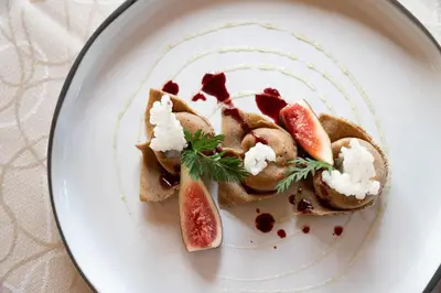 a plate of food with fruit and cheese on it at Hotel Burggräflerhof in Merano