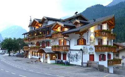 a building with balconies on the side of a street at Hotel B&B Andreas in Canazei