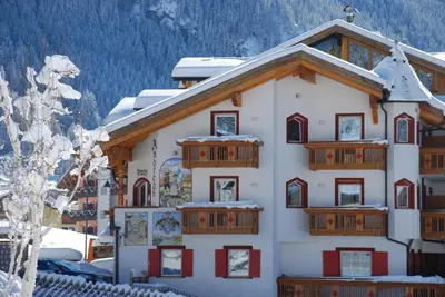 a large building with snow on the roof at Hotel B&B Andreas in Canazei