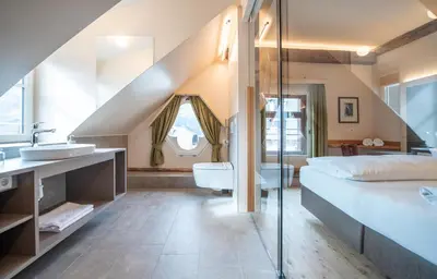 a bathroom with a bed and a sink at Hotel Gassenwirt in Chienes