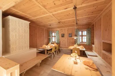 a room with wooden walls and tables and chairs at Hotel Gassenwirt in Chienes