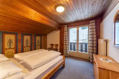 a bedroom with two beds and a wooden ceiling at Residence Soratru in San Vigilio Di Marebbe