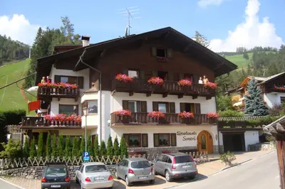 a building with cars parked in front of it at Residence Soratru in San Vigilio Di Marebbe