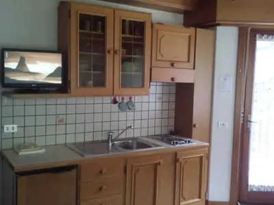 a kitchen with a sink and a tv on the wall at Residence Soratru in San Vigilio Di Marebbe