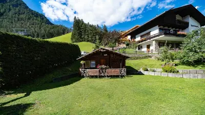 a house on a hill with a grass yard at Residence Soratru in San Vigilio Di Marebbe