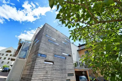 a tall building with a glass facade at Design Lodge The Cube in Ortisei