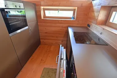 a small kitchen with a stove and a refrigerator at Design Lodge The Cube in Ortisei