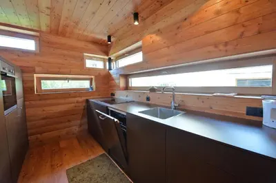 a kitchen with a sink and wooden walls at Design Lodge The Cube in Ortisei