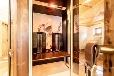 a dressing room with a glass door and a shelf at Hotel Dolomiti in La Villa