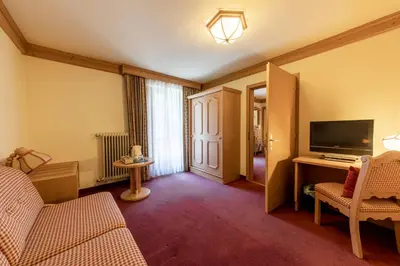 a living room with a couch and a television at Hotel Dolomiti in La Villa