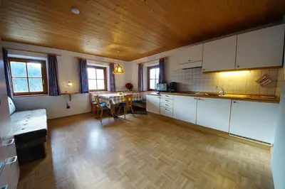 a kitchen with white cabinets and a table in it at Soroea in San Vigilio Di Marebbe