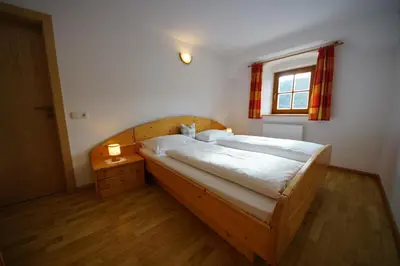 a bedroom with a wooden bed and a window at Soroea in San Vigilio Di Marebbe