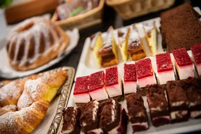 a table topped with different types of pastries and pies at Hotel Tiffany in Merano