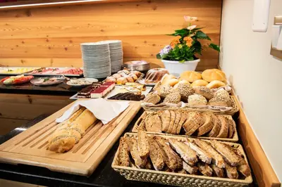 a buffet with various types of bread and pastries at Hotel Tiffany in Merano