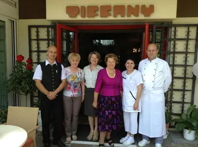 a family poses for a picture in front of a restaurant at Hotel Tiffany in Merano