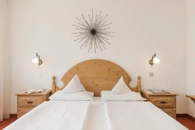 a bedroom with a large white bed with white sheets at Pension Monika in Lagundo
