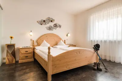 a bedroom with a wooden bed and a telescope at Pension Monika in Lagundo