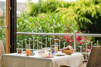 a table with a white table cloth and a bowl of food at Pension Monika in Lagundo