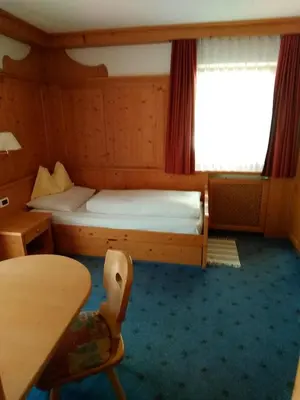 a small room with a bed and a table at La Cianò in Corvara in Badia