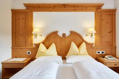 two beds in a hotel room with white pillows at La Cianò in Corvara in Badia
