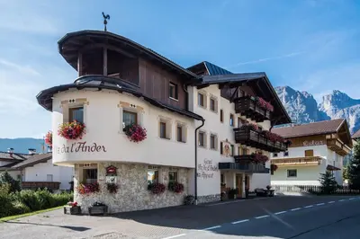 a hotel room with a bed and a table at Garnì Piz da L'Ander in Corvara in Badia