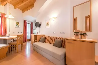 a kitchen with white cabinets and a counter top at Garnì Piz da L'Ander in Corvara in Badia
