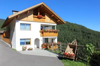 a house with a balcony and flowers on it at Leitnerhof in Terento