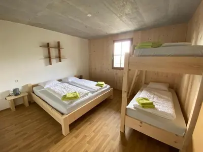 a bedroom with two bunk beds and a window at Familyparadies GAMPLALM in Lana